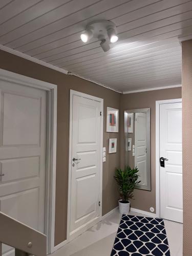 a hallway with two white doors and a potted plant at 2 minute walk from ONS exhibiton area in Stavanger