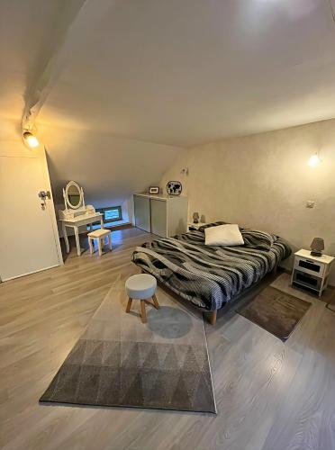a bedroom with a large bed and a table at L'Échappée en Sandales in La Gacilly