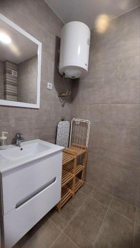 a bathroom with a white sink and a mirror at My Life 19 - Green Hill in Soko Banja