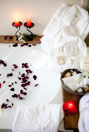 a bed with petals on it with candles and flowers at Fresco Cave Suites Cappadocia in Urgup