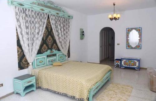 a bedroom with a bed with a blue canopy at Dar morjana in Chott Meriem
