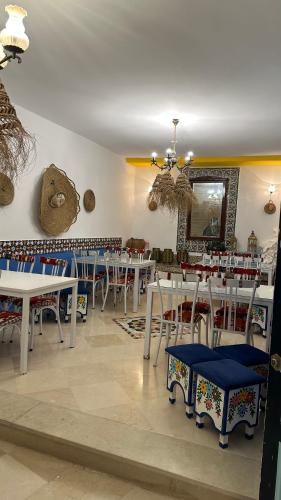 a restaurant with tables and chairs and a teddy bear on the wall at Dar morjana in Chott Meriem