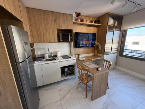a kitchen with a stainless steel refrigerator and a table at Studio JP Redenção in Porto Alegre