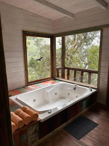 a large bath tub in a room with a window at Tacuapí Lodge in Aristóbulo del Valle