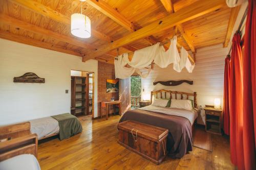 a bedroom with two beds and a wooden ceiling at Tacuapí Lodge in Aristóbulo del Valle