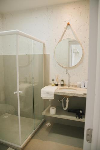 a bathroom with a shower and a sink and a mirror at Curima Milagres in Passo de Camarajibe