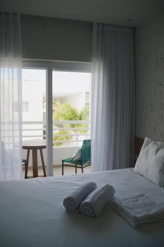 a bedroom with a bed with two towels on it at Curima Milagres in Passo de Camarajibe