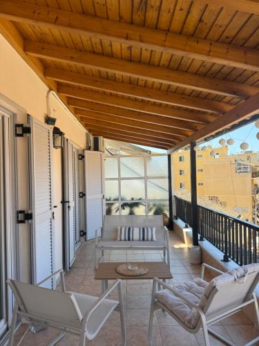 a patio with a table and chairs on a balcony at Dina Apartment in Ágios Rókkos