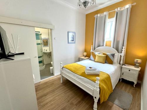 a bedroom with a white bed and a bathroom at Hostel das Flores in Senhora da Hora