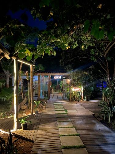 a walkway in a garden at night at Mato Verde Hospedaria - À beira da Lagoa - Praia do Rosa in Imbituba