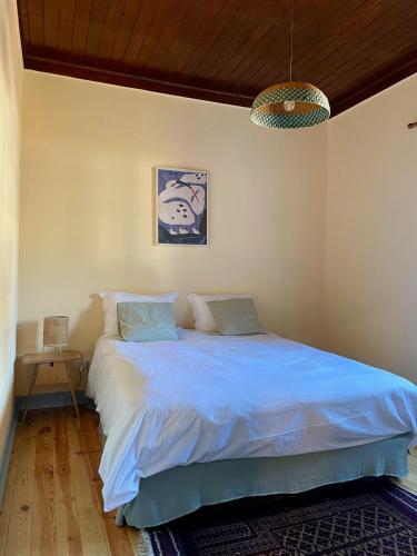 a bedroom with a bed with a blue comforter at Casa Terra in Rio Maior