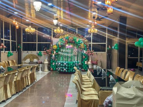 a banquet hall with a large green fountain in the middle at corbett motel in Rāmnagar