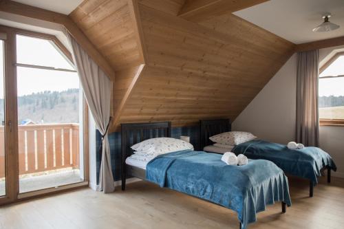 two beds in a room with a balcony at Willa Widokowe Wzgórze in Falsztyn