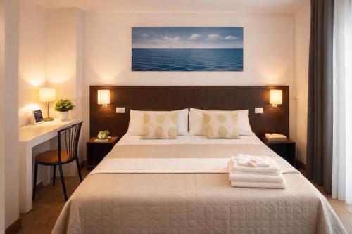 ein Schlafzimmer mit einem Bett, auf dem zwei Handtücher liegen in der Unterkunft Hotel Okinawa in Rimini