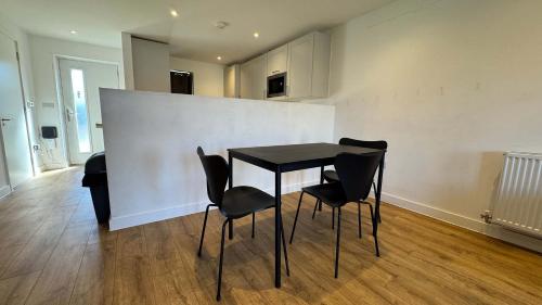 a dining room with a black table and chairs at Joyful Management - A Mordern Semi-Detached House with 3 bedroom in Manchester