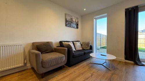 a living room with a couch and a chair and a table at Joyful Management - A Mordern Semi-Detached House with 3 bedroom in Manchester