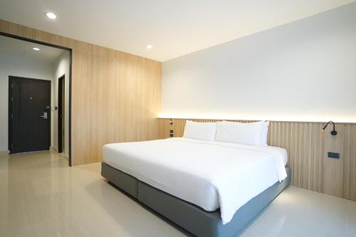 a bedroom with a large white bed in it at Manditel North Pattaya in North Pattaya