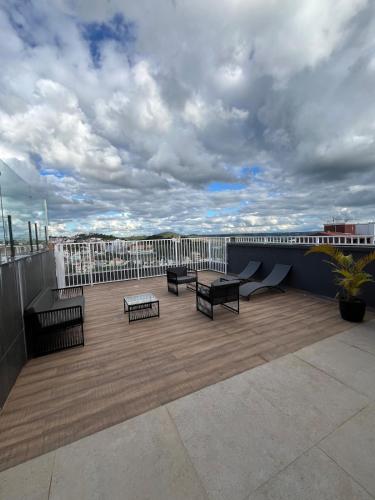 a patio with benches and tables on a roof at Studio Aura in Barbacena