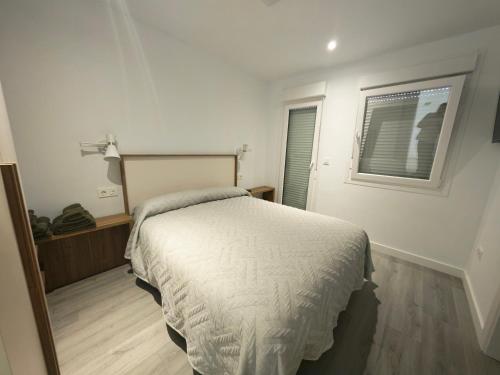 a bedroom with a bed and a window at Hostal Viña in Outes