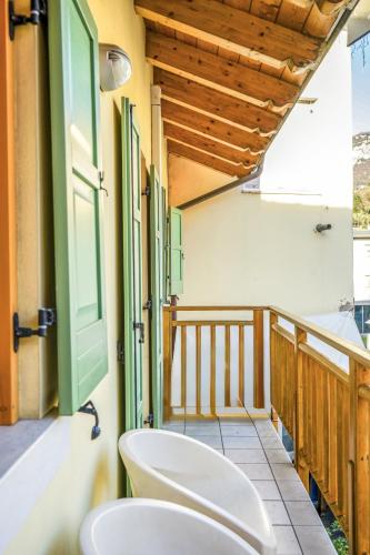 a bathroom with a toilet and a tub and a window at Windshouse Apartments in Nago-Torbole