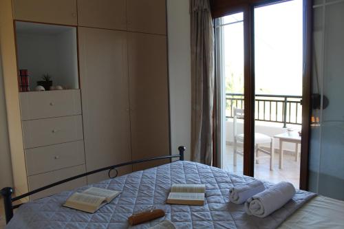 a bedroom with a bed with towels and a balcony at Vakis Apartments 1 in Romanón