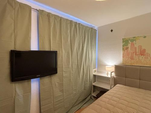 a bedroom with a flat screen tv on the wall at Privatquartier im Ortskern von Westerstede in Westerstede