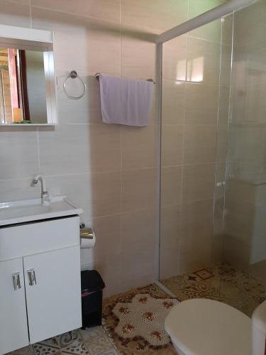 a bathroom with a shower and a sink and a toilet at Chalés sítio anjo gabriel 3 in Urubici