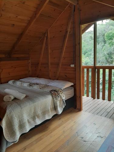 a bed in a wooden room in a cabin at Chalés sítio anjo gabriel 3 in Urubici