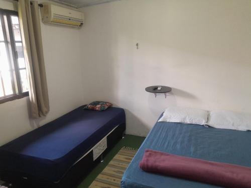 a room with two beds and a window at Nosso Lar in Porto Velho