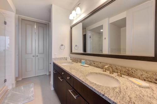 a bathroom with two sinks and a large mirror at Hanover Post Oak in Houston