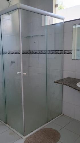 a glass shower in a bathroom with a sink at Bela Casa PX as praias in São Luís