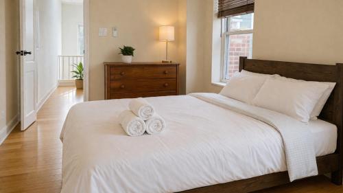 a bedroom with a bed with two towels on it at The Heights Haven, Spacious 6 Bedrooms Townhouse with Patio in New York
