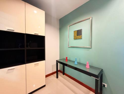 a room with a black table and a television at THE MAISON Phuket in Ban Lo Long