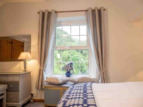 a bedroom with a bed and a window at Cwm Ffernol in Machynlleth