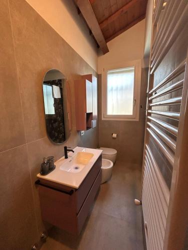 a bathroom with a sink and a toilet and a mirror at CasaVolta in Padova