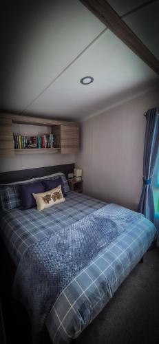 a bedroom with a bed with a blue comforter at K&S at 1529 in Selsey