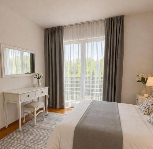 a bedroom with a bed and a desk and a window at Bonita Apartments in Mostar