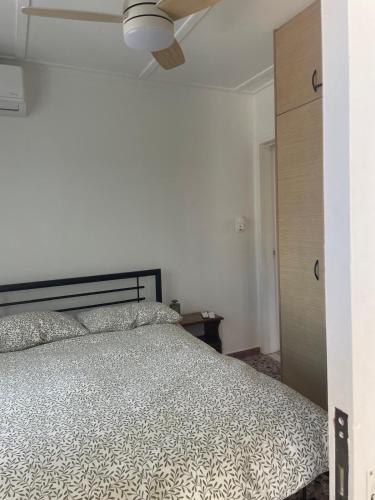 a bedroom with a bed and a ceiling fan at Lilac House Kefalonia in Ratzaklíon