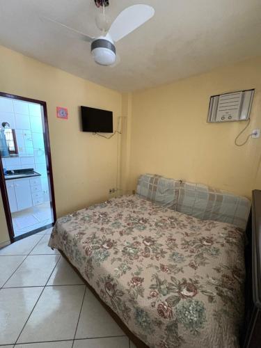 a bedroom with a bed and a ceiling fan at Apartamento do Lala in Arraial do Cabo