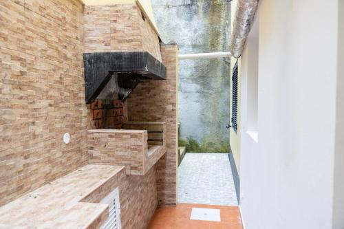 a kitchen with a brick wall and a stove at Furnas Panorama House in Furnas