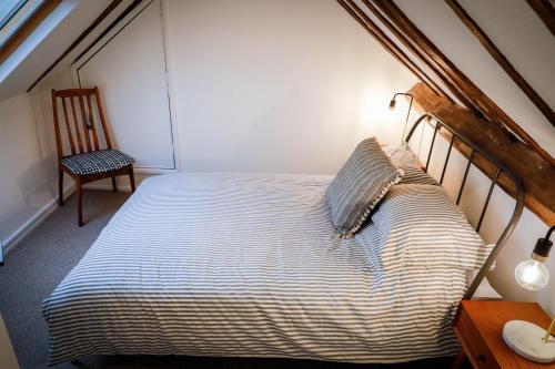 a bedroom with a bed and a chair in a room at Spacious 4 Bed House Sleeps 8 in Quorn Near Loughborough in Quorndon