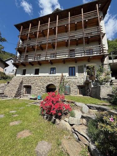 a large stone building with a flowering plant in front of it at Appartamento LA ROSA in Ponto Valentino