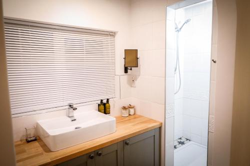 a bathroom with a sink and a shower at Spacious 4 Bed House Sleeps 8 in Quorn Near Loughborough in Quorndon