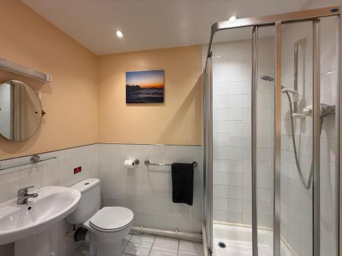 a bathroom with a shower and a toilet and a sink at Apartment 2 Maritime House in Portland