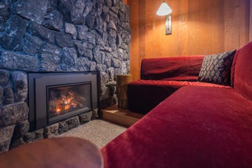 a room with a stone wall and a fireplace at The Icelander at Mammoth Point in Mammoth Lakes