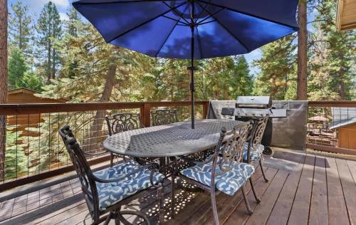 a table and chairs on a deck with an umbrella at The Speckled Gem in Kings Beach
