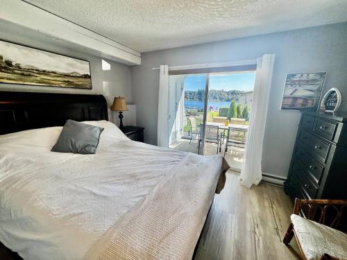 a bedroom with a bed and a window with a view at Lakefront Condo and Beach in Shawnigan Lake