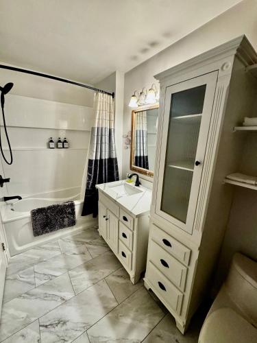 a bathroom with a white sink and a tub and a mirror at Lakefront Condo and Beach in Shawnigan Lake