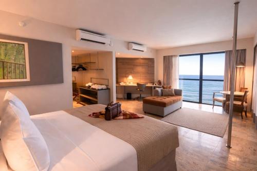 a hotel room with a large bed and a living room at Hotel Atlante Plaza in Recife