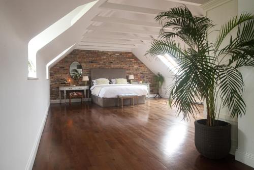 a bedroom with a bed and a palm tree in it at Courtyard Cottages in Tralee